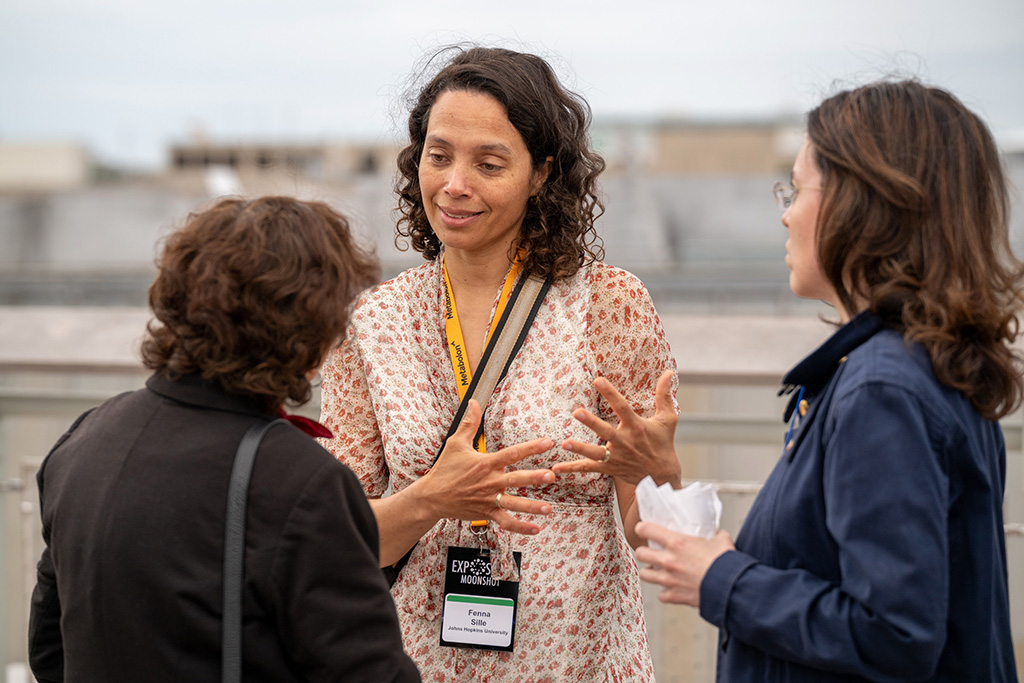 The photo shows Dr. Sillé at the Exposome Moonshot Forum wearing a dress she made herself.
